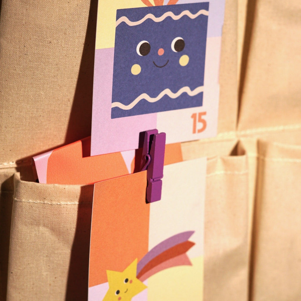 Adventskarte mit der Zahl 15 an einer Papiertüte mit Wäscheklammern