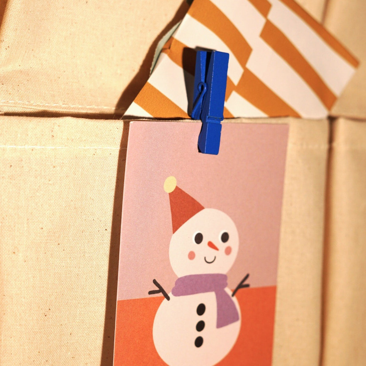 Adventskarte mit Schneemann an einer Papiertüte