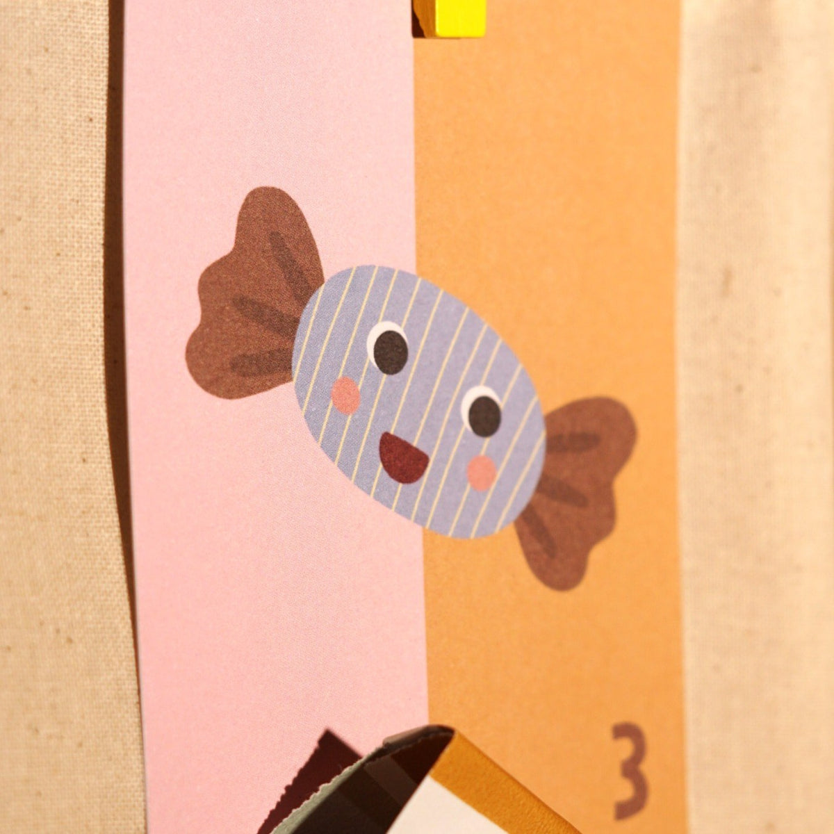 Adventskarte mit Bonbon und der Zahl 3 an einer Papiertüte
