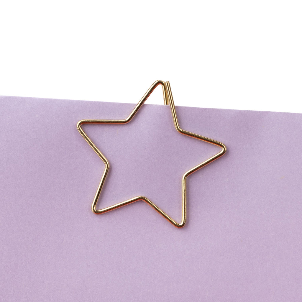 Goldener Clip in Sternform an einem Papierrand