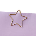 Goldener Clip in Sternform an einem Papierrand
