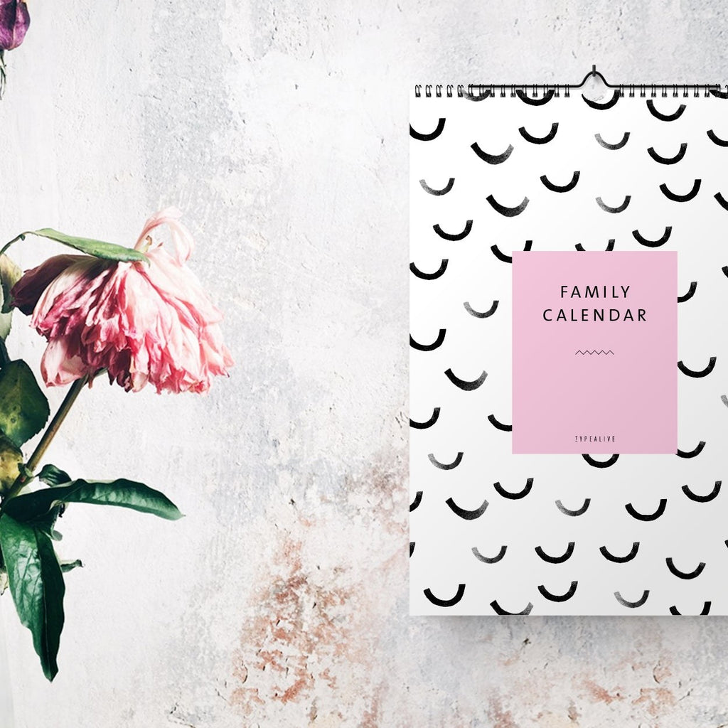 Kalender an einer Betonwand neben Blumen