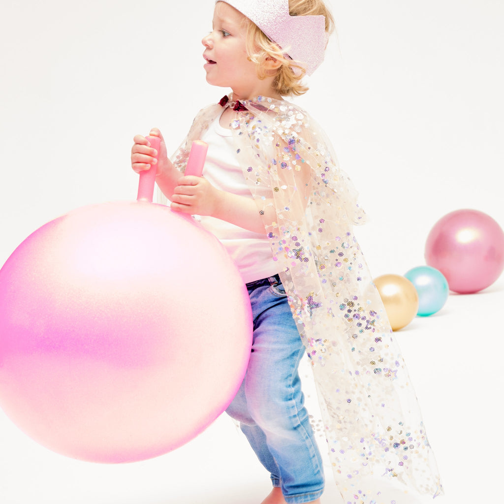 Kind im Feenumhang mit rosa Ballon