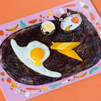 Lila Frühstücksbrettchen mit schwarzer Katze und Spiegelei
