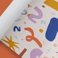 Gerolltes Geschenkpapier mit bunten Formen