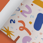 Gerolltes Geschenkpapier mit bunten Formen