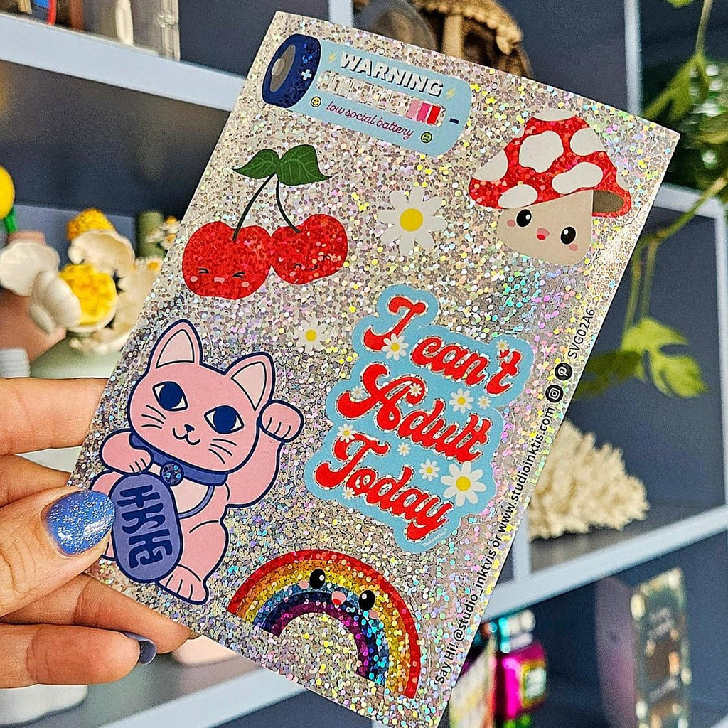 Glitzer-Stickerbogen mit Winkekatze und Kirschen in der Hand vor einem Regal