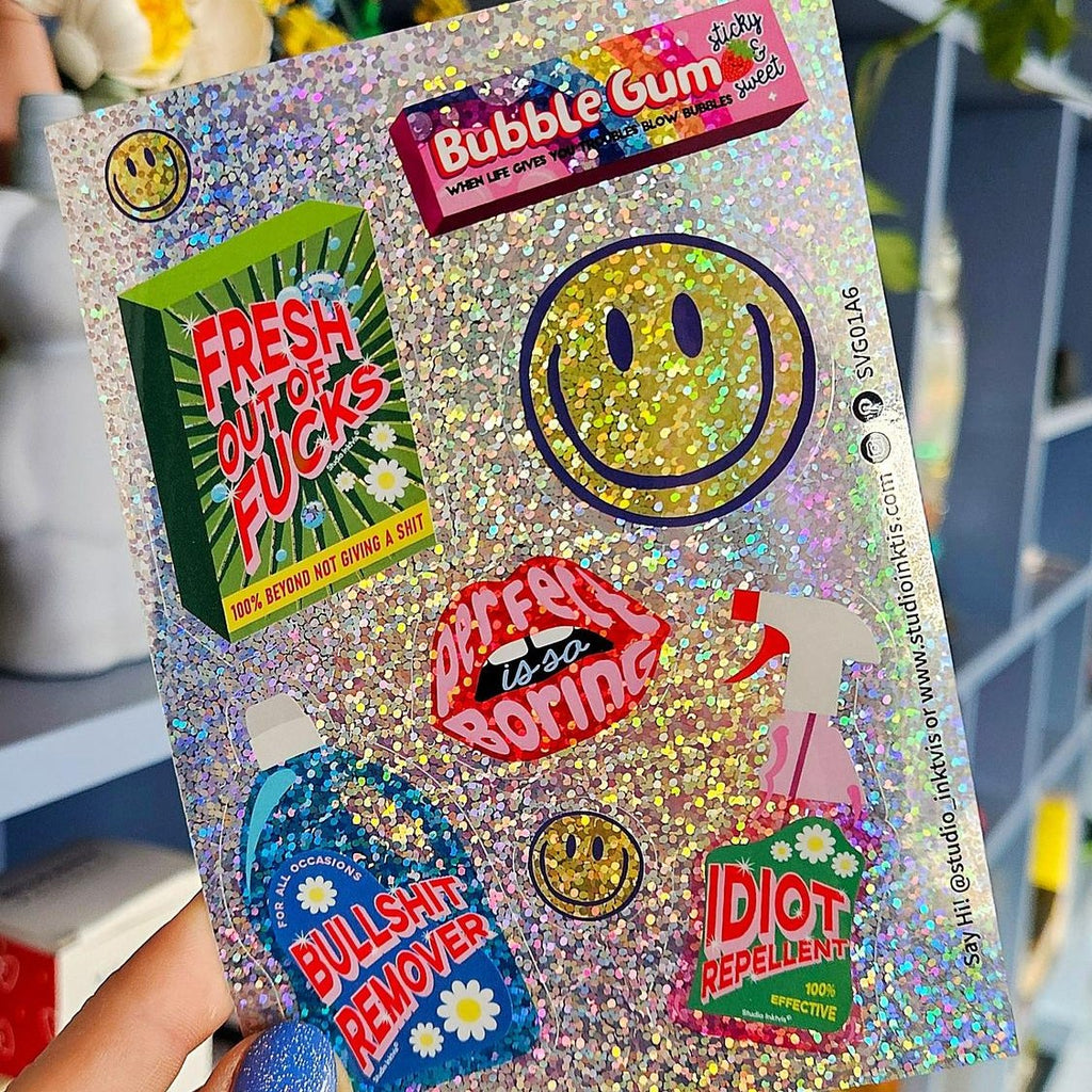 Glitzer-Stickerbogen mit Smiley und Sprüchen in der Hand vor einem Regal