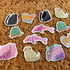 Kleine Tiersticker mit Glitzer auf braunem Teppich