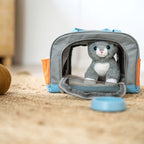 Plüschkatze in der Tragetasche, davor ein blauer Napf