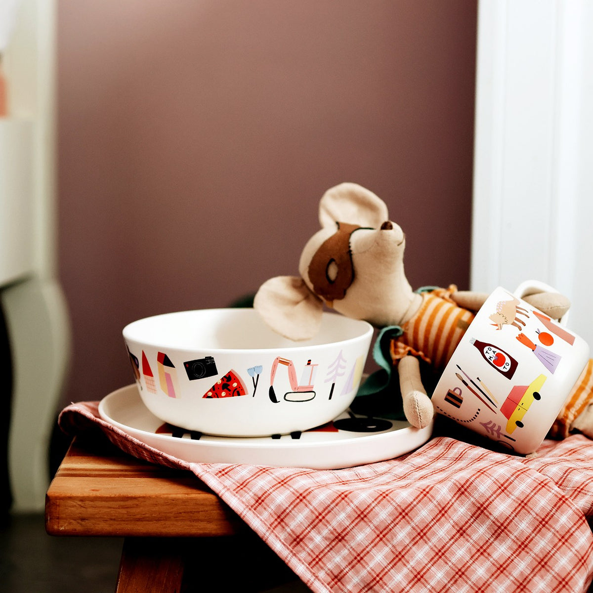 Schüssel und Tasse Happy mit Stoffmaus auf einem karierten Tuch