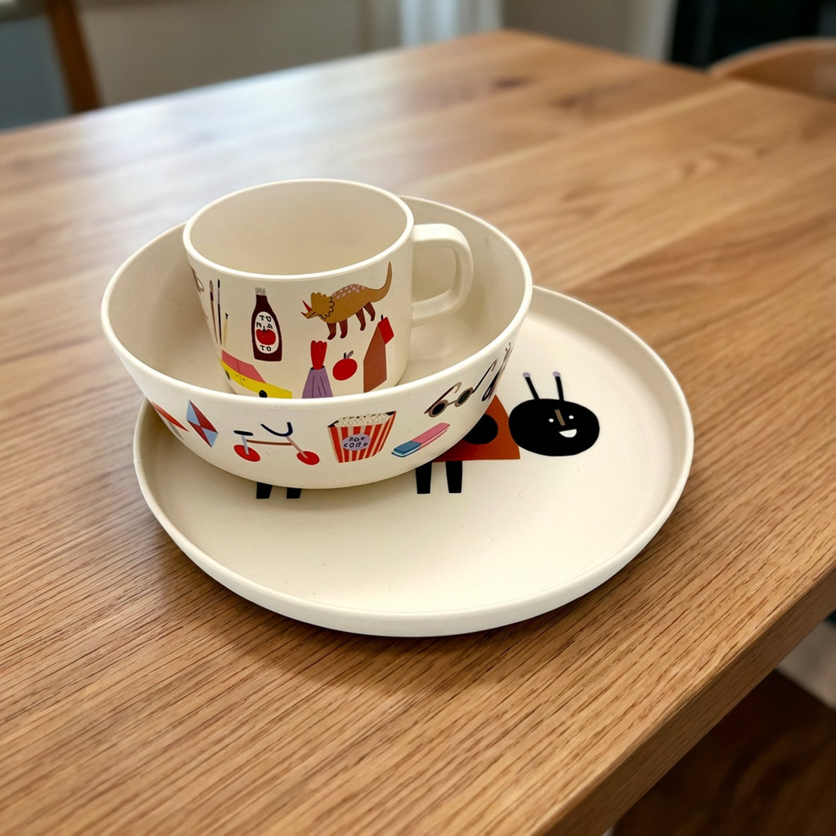 Kindertasse in der passenden Schüssel auf einem Teller