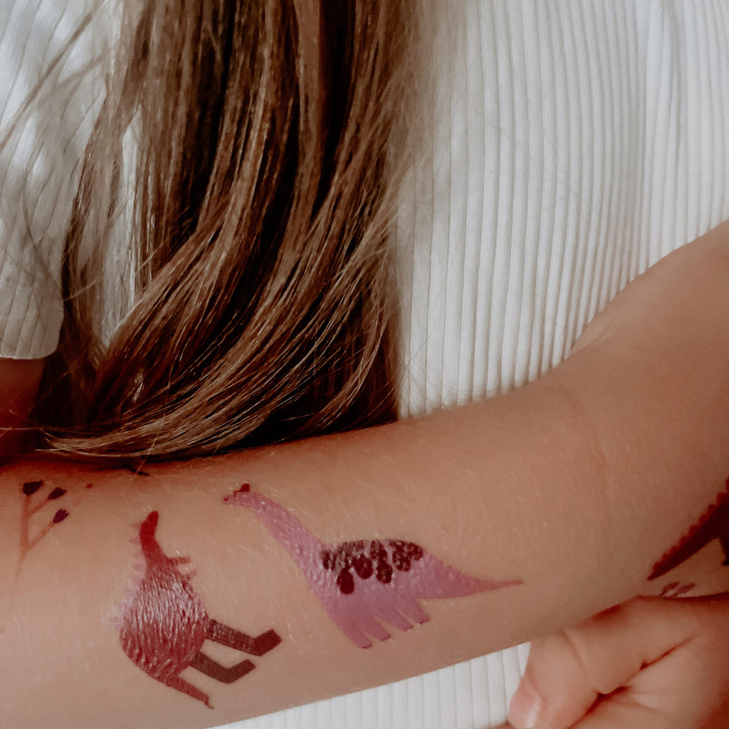 Dino-Tattoos auf einem Kinderarm