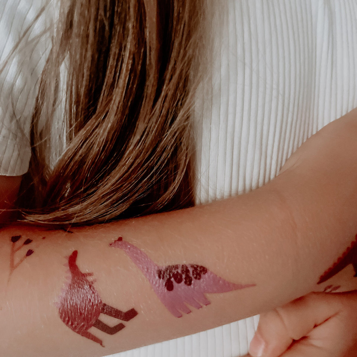 Dino-Tattoos auf einem Kinderarm