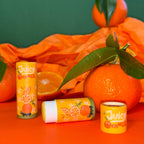 Lippenbalsam geöffnet neben Mandarinen