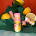 Rosa Lippenbalsam-Hülse Zesty Lemon vor Zitronen