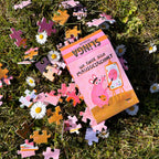 Schachtel mit Puzzleteilen im Gras