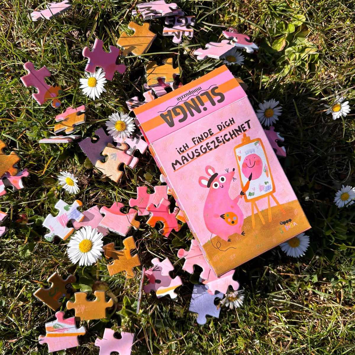 Schachtel mit Puzzleteilen im Gras