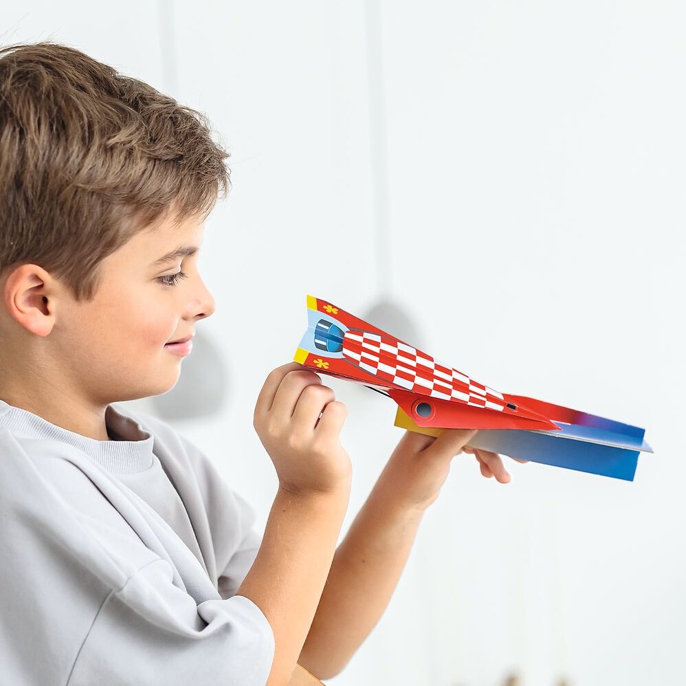 Junge lässt einen Papierflieger fliegen