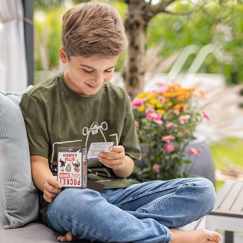 Junge spielt Pocket Quiz auf der Terrasse