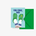 Postkarte You Croc, Dad mit Füßen in grünen Clogs und Tennissocken, grüner Umschlag