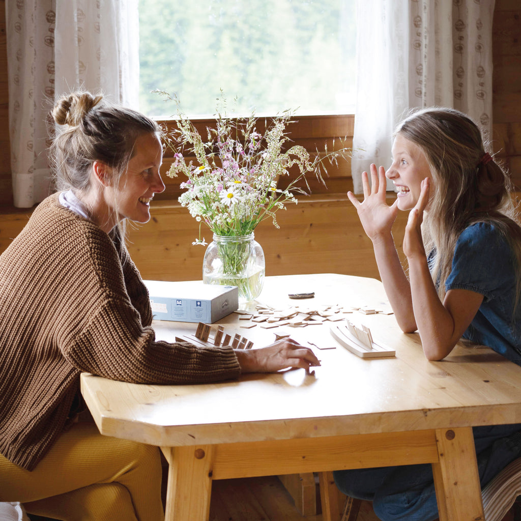Zwei Frauen spielen Rummy an einem Holztisch