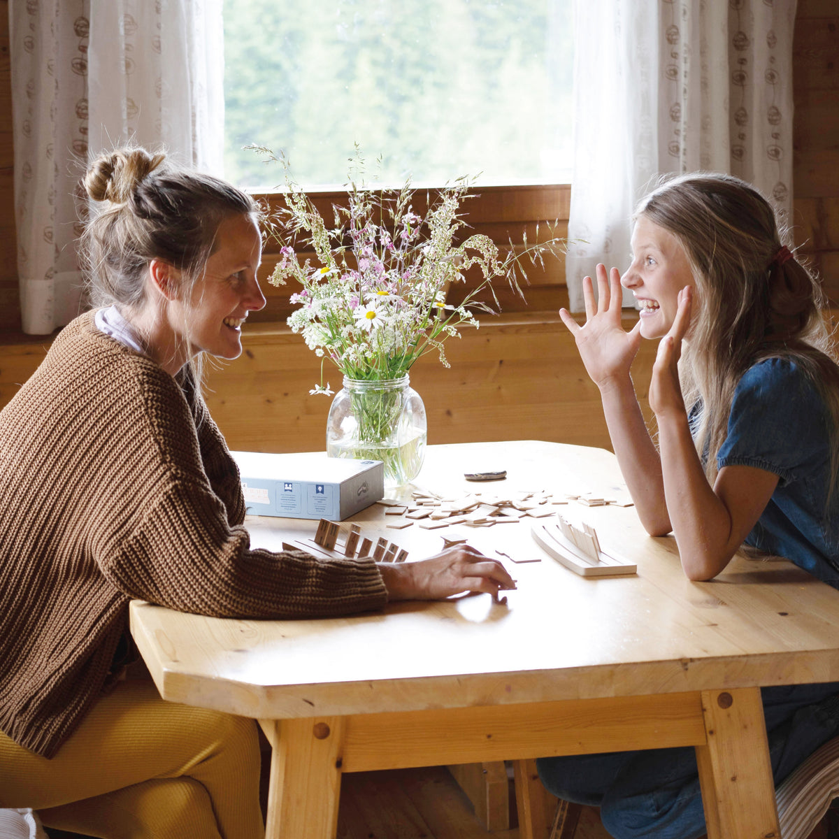Zwei Frauen spielen Rummy an einem Holztisch