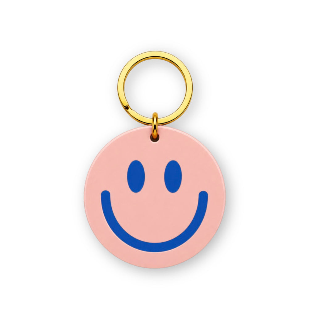 Runder rosa Schlüsselanhänger mit blauem Smiley und goldenem Ring