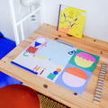 Schreibtischunterlage mit ABC-Illustration auf einem Holzschreibtisch