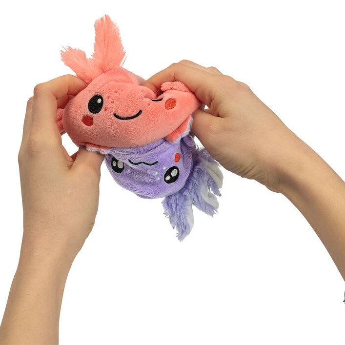 Hände wenden den Axolotl von rosa auf lila